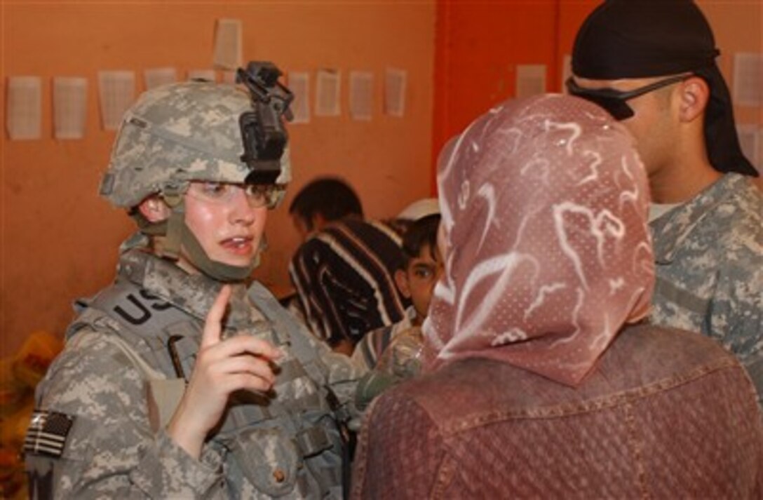 Army 1st Lt. Robyn Jacobs (left) speaks with a woman on the security council during a humanitarian aid delivery at the Zafaraniyah Government Center in the Zafaraniyah area of East Baghdad, Iraq, on June 6, 2007.  Jacobs is from Headquarters Company, 2nd Battalion, 17th Field Artillery Regiment, 2nd Brigade Combat Team, 2nd Infantry Division.  
