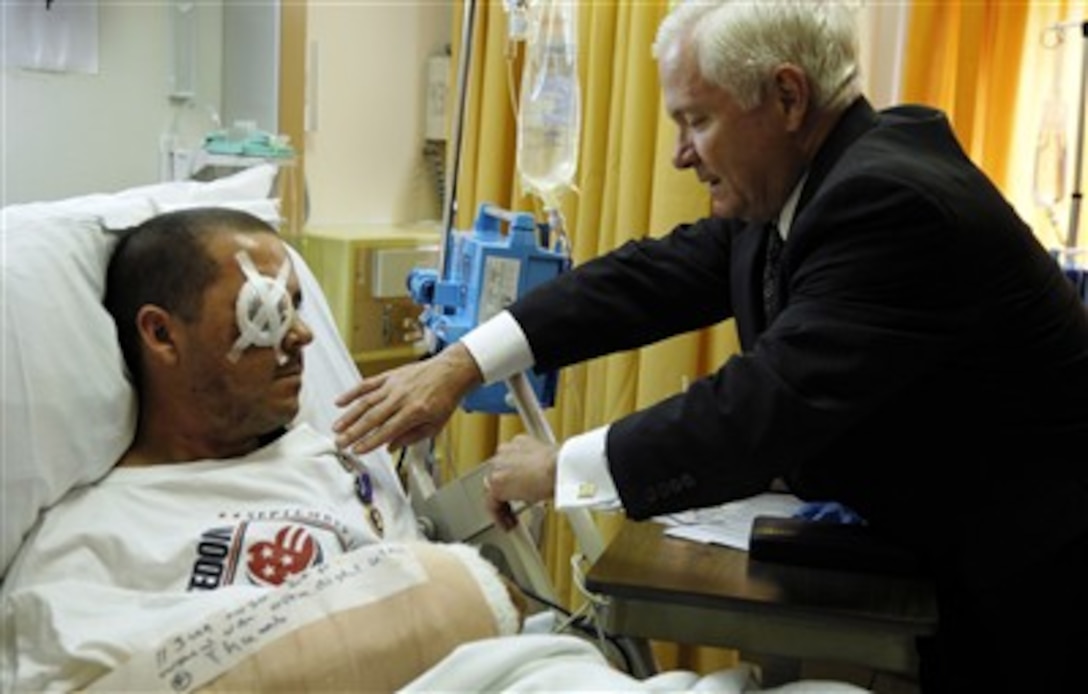 Secretary of Defense Robert M. Gates presents the Purple Heart medal to U.S. Army Staff Sgt. Brent A. Homan at the Landstuhl Regional Medical Center in Germany on June 13, 2007.  Homan was wounded in action in Balad, Iraq, on June 11, 2007.  Gates is visiting troops at Landstuhl before attending the two-day formal NATO Ministerial meetings in Brussels, Belgium.  