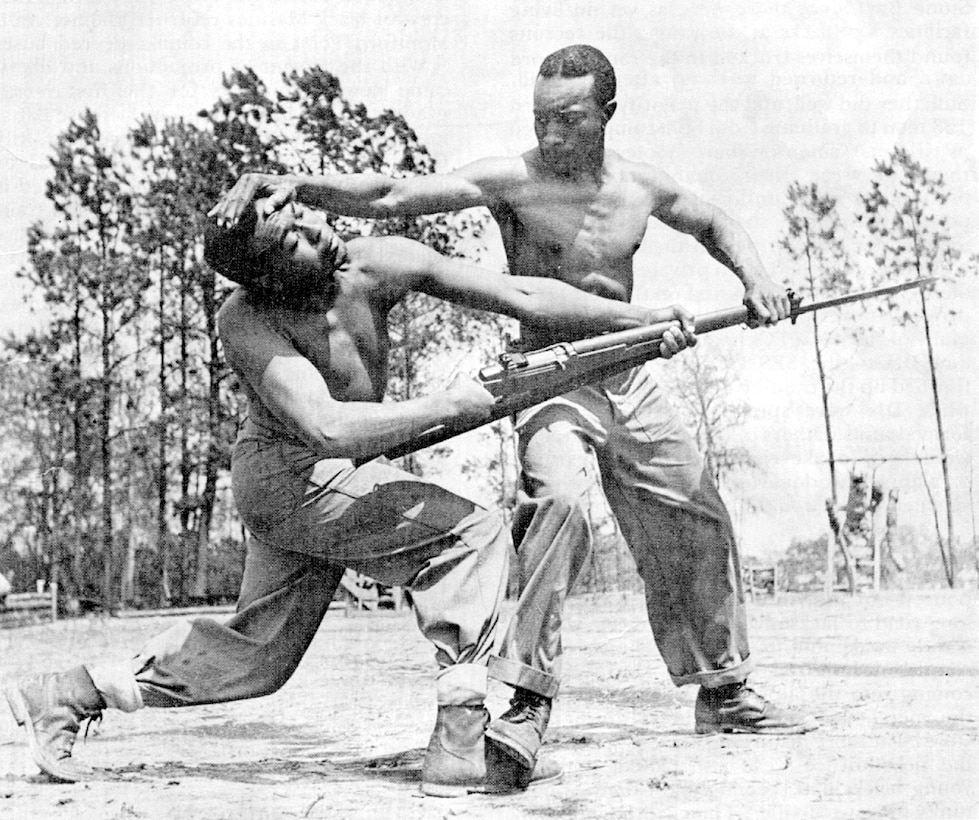 Cpl. Alvin "Tony" Ghazlo, the senior bayonet and unarmed combat instructor at Montford Point, demonstrates a disarming technique on his assistant, Private Ernest "Judo" Jones. Between 1942 and 1947, approximately 20,000 African-American recruits received training at Montford Point Camp. Photo by: Official Marine Corps Photo