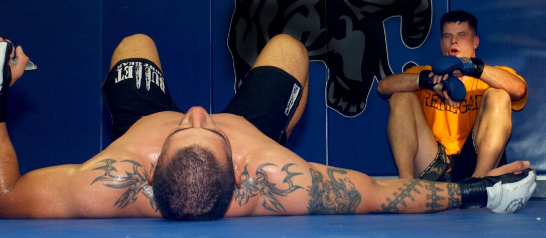 Exhausted, Cpl. George Lockhart, a cryptological analyst with 2nd Radio Battalion, takes a moment to recharge between rounds during his daily sparring sessions as 1st Lt. Brian Stann catches his breath at Wright's Gym June 13. Official Marine Corps photo by Cpl. Michael Knight.