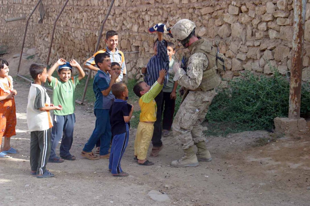 Seaman Mike Ewing, corpsman, Charlie Company, 1/3, plays with a group of Iraqi children during a census patrol June 13, in Haqlaniyah.