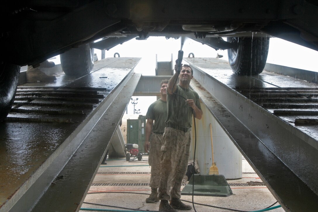 Cpl. Chad A. Johnson, a radio battalion operator for the 26th Marine Expeditionary Unit, washes the underside of a humvee, June 15, 2007 at Naval Station Rota, Spain.  The 26th MEU is preparing to return to Camp Lejeune following their six-month deployment in support of the Global War on Terror.
