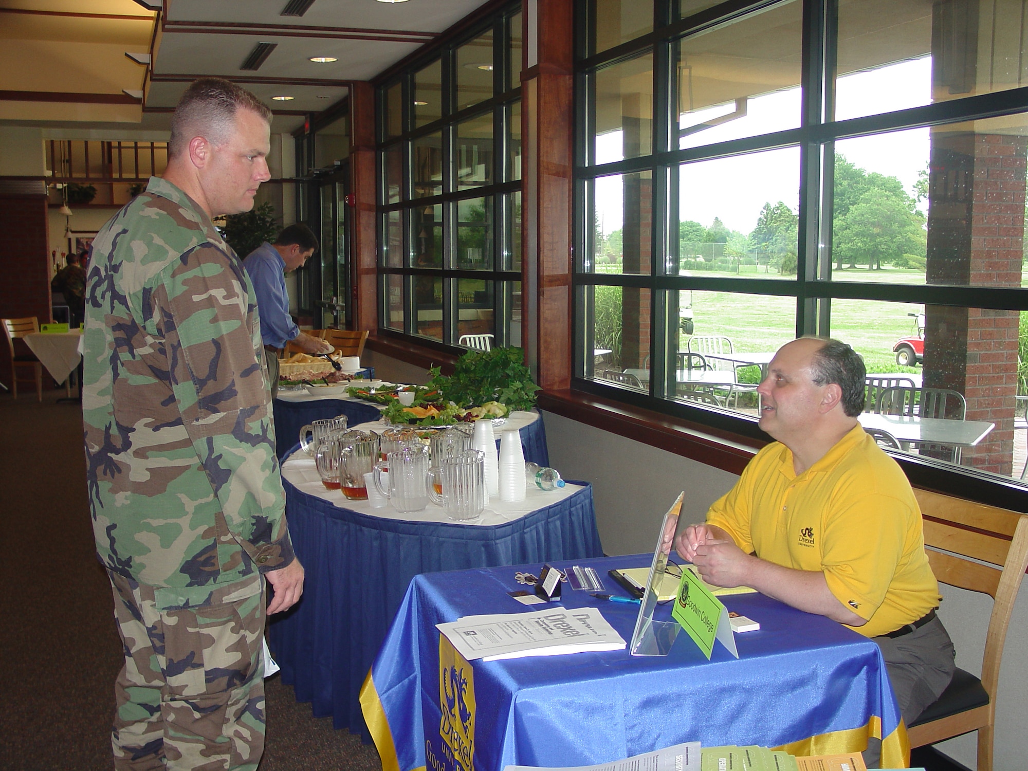 Capt. Paul Sortor, 605th Aircraft Maintenance Squadron section commander, speaks with a Drexel University representative at "Education on the Green" at Falcon Creek Golf Course here June 15. 
