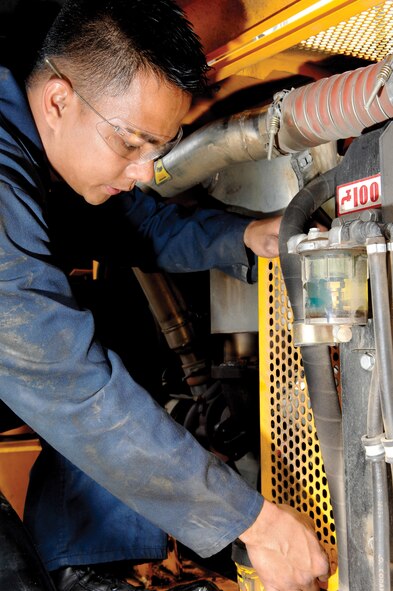 MCCHORD AIR FORCE BASE, Wash. -- Senior Airman Vincent Garcia, 62nd Logistics Readiness Squadron, replaces a cover in the engine compartment of a front-end loader during a safety inspection on May 23, 2007.  (U.S. Air Force photo/Abner Guzman)