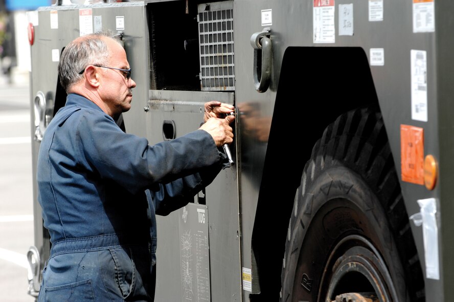 MCCHORD AIR FORCE BASE, Wash. -- Jimmy Hahn removes the side panels on an aircraft tow tractor on May 23, 2007 prior to inserting weights used to balance the vehicle while in operation. (U.S. Air Force photo/Abner Guzman)