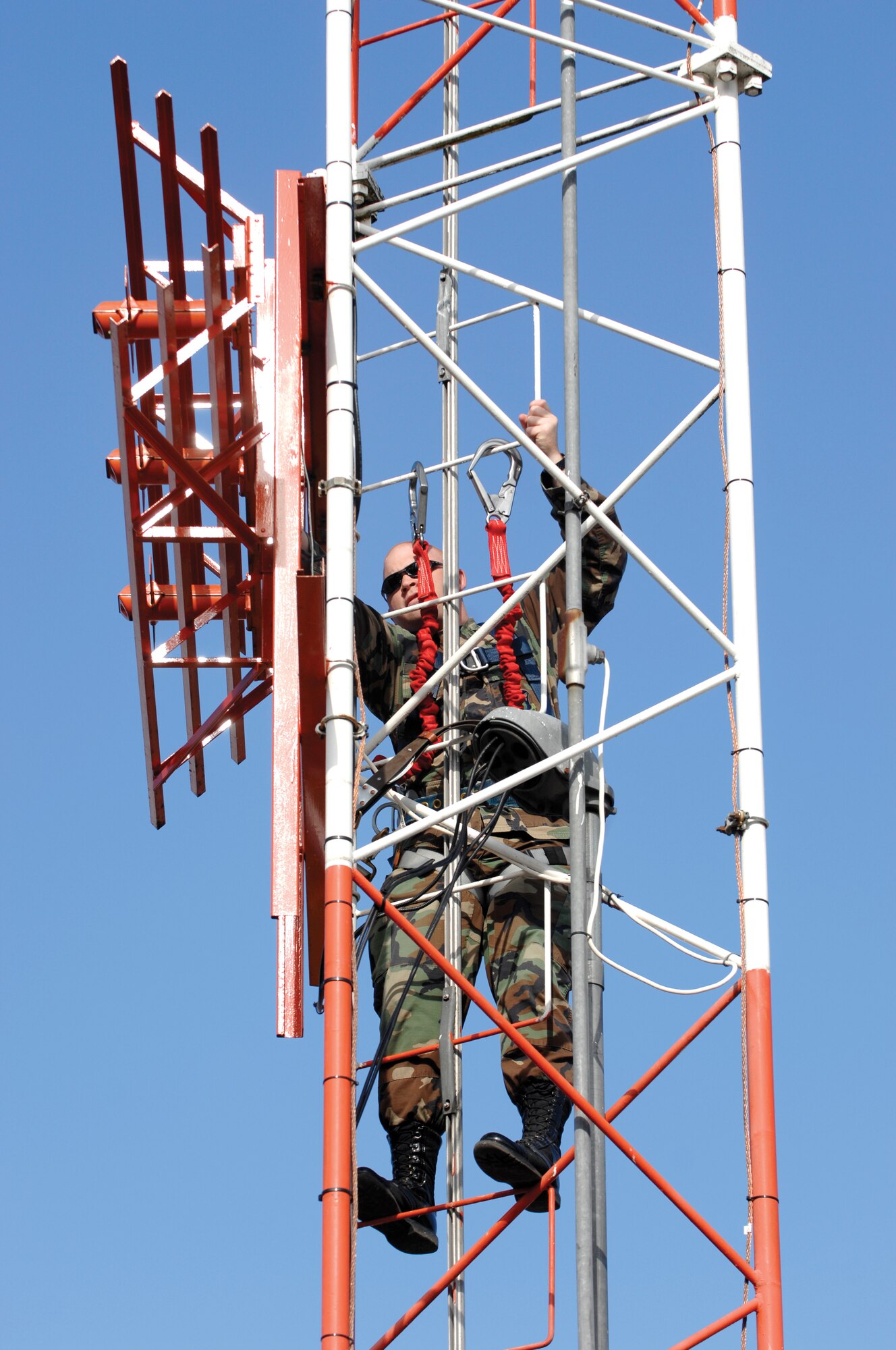 Senior Airman Nicholas Higbee, an airfield systems maintenance technician assigned to the 62nd Communications Squadron, performs corrosion control on an antenna situated atop the Glideslope tower on Tuesday May 22, 2007. (U.S. Air Force photo/Abner Guzman)(Released)