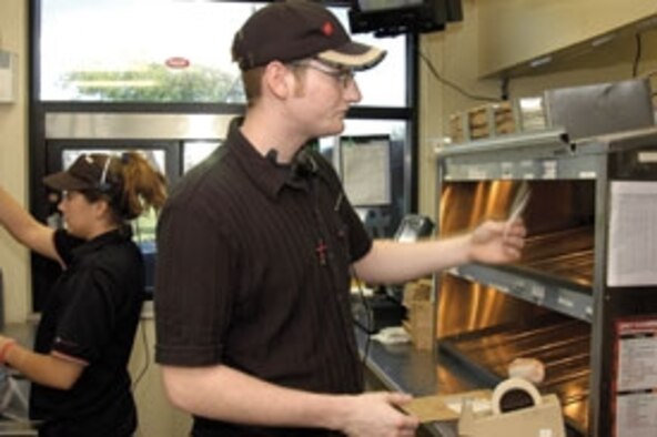 At home in the Tinker Burger King as assistant manager, Greg Templeton expedites orders as Carla Surrett works the drive through. The Army Air Force Exchange Service employee spent ten months in Iraq where he served deployed troops as an AAFES exchange store manager.  (Air Force photo by Margo Wright)