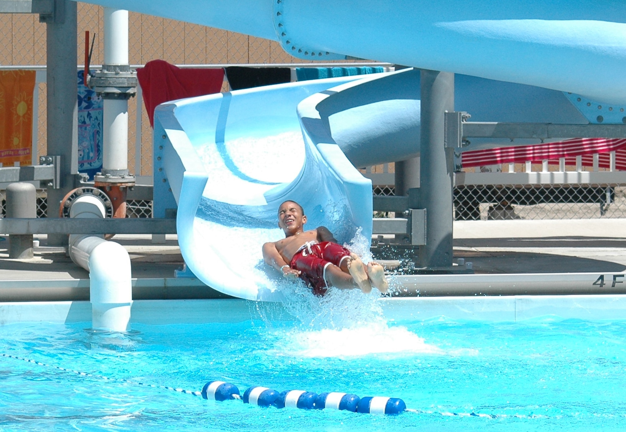 Little Warrior Jacob, 12, cools off on the water slide during open swimming at the base pool Tuesday. Open swimming starts at 1 p.m. everyday. (U.S. Air Force photo / Valerie Mullett)