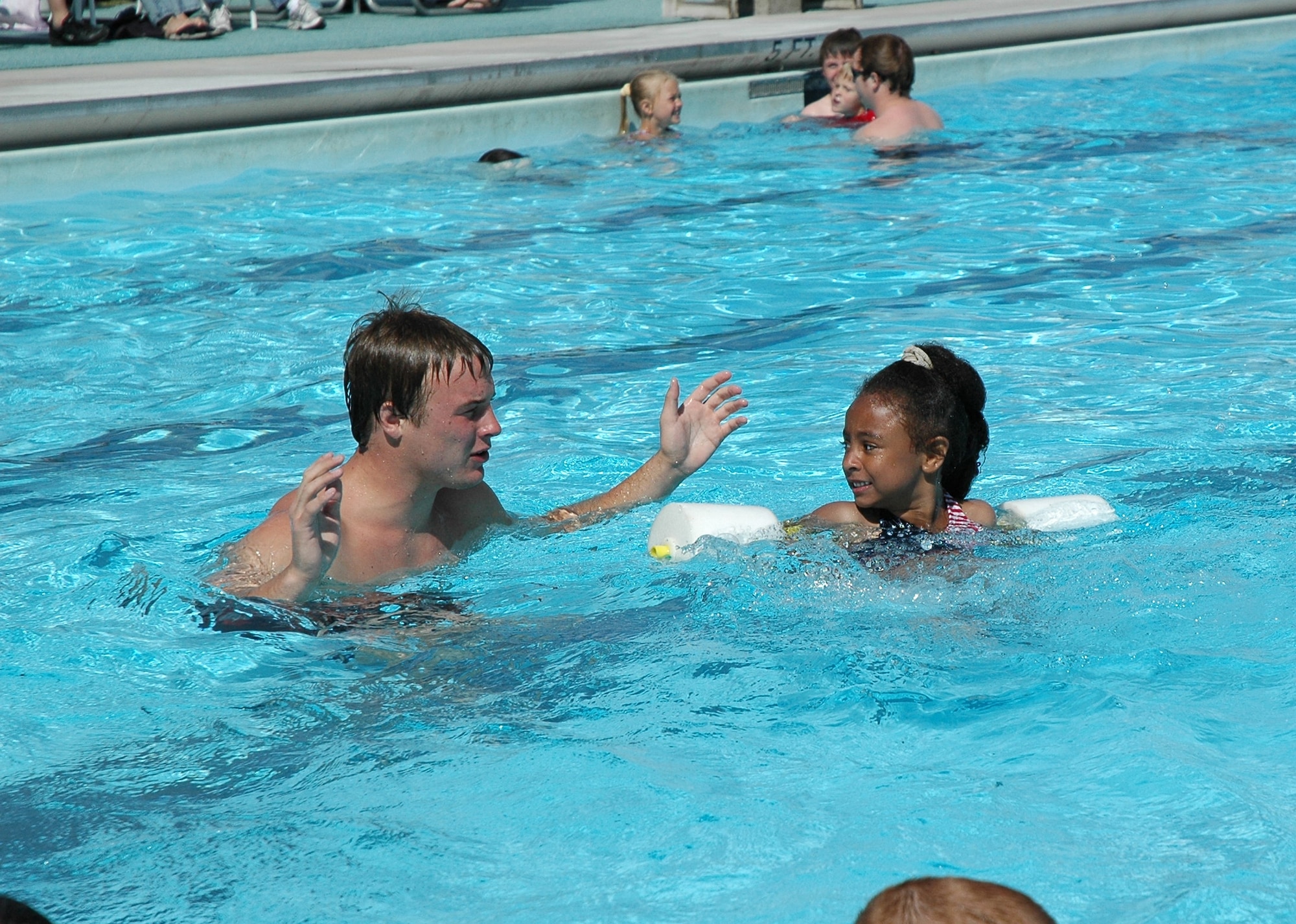Lifeguard and swimming instructor Steve Hystad shows Little Warrior Jessica that she is floating on her own during her second day of swimming lessons Tuesday. 
Pool parking is no longer available behind the Sports and Fitness Center. Access from 3rd Ave. N. is no longer permitted. 
Pool patrons should use the Elkhorn Dining Facility parking lot off 75th St. N. (U.S. Air Force photo / Valerie Mullett)
