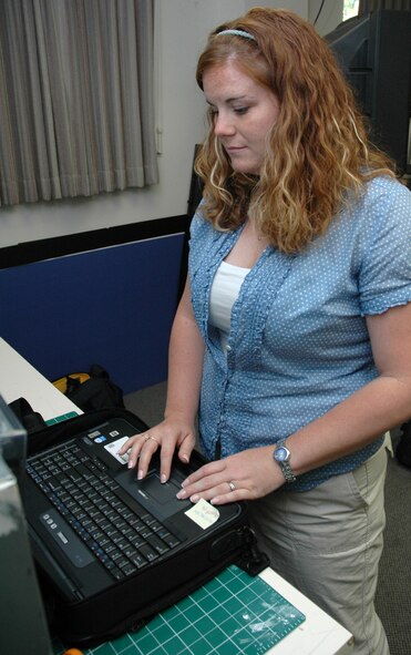 Christy Mason, a photographer and videographer at the base multimedia center, checks in a lap top and LCD projector from a customer.  Ms. Mason is also a  staff sergeant specializing in videography for the Montana Air National Guard’s 120th Fighter Wing. (U.S. Air Force photo / Airman 1st Class Dillon White)