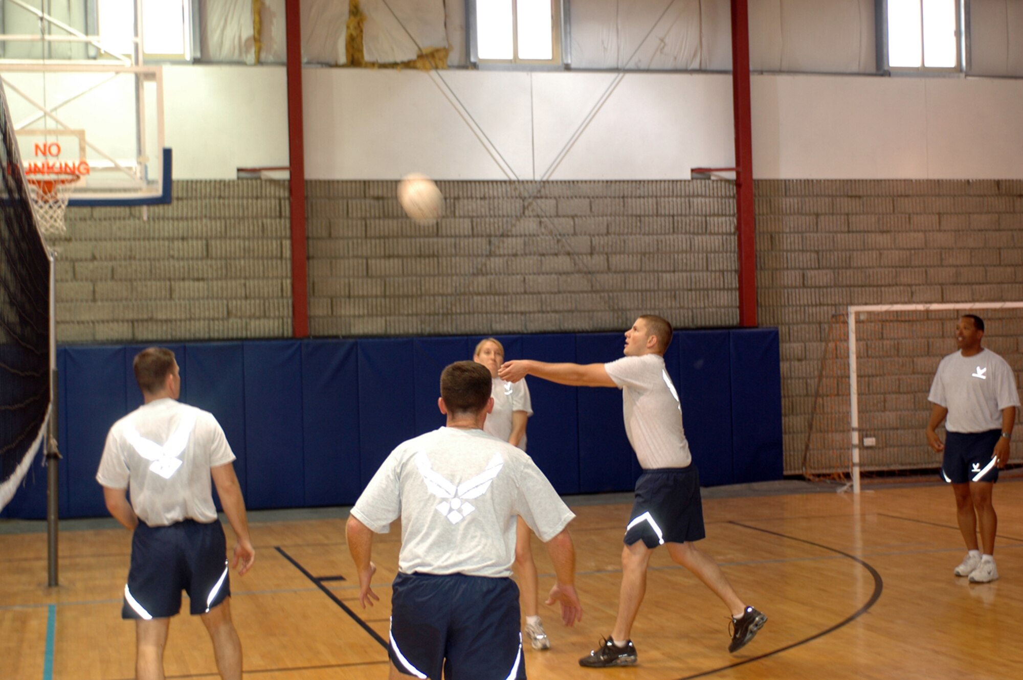 A member of the 379th Air Expeditionary Wing passes a volleyball during a game between  wing staff agencies. The game was organized to wrap up Wingman Week festivities. (U.S. Air Force photo by Senior Airman Clark Staehle)