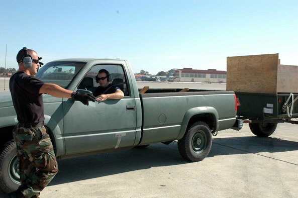 Senior Airman Brian Harmon directs Staff Sgt. Cory Morris during a C-5 Galaxy engine running on (and) offload team practice June 11 at Travis Air Force Base, Calif. The practice is part of the 60th Aerial Port Squadron's preparations for the 2007 Air Mobility Command's Expeditionary Rodeo to be held in July at McChord AFB, Wash. The AMC readiness competition will test competitors' abilities in all aspects of their career fields. (U.S. Air Force photo/Staff Sgt. Candy Knight) 