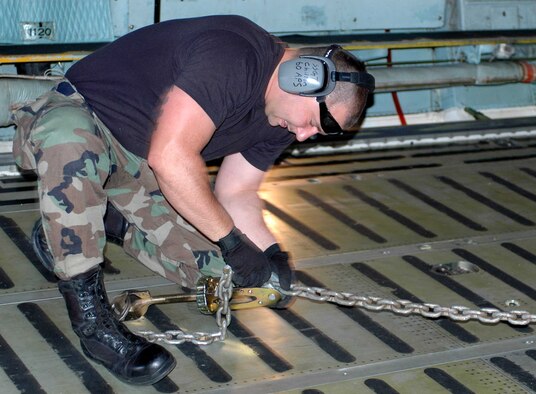Staff Sgt. Joseph Chilton fastens cargo inside a C-5 Galaxy during an engine running on (and) offload team practice June 11 at Travis Air Force Base, Calif. The 60th Aerial Port Squadron team must load and unload a C-5 and a C-17 Globemaster III in the fastest time possible with no safety violations. The practice is in preparation for the 2007 Air Mobility Command's Expeditionary Rodeo to be held in July at McChord AFB, Wash. (U.S. Air Force photo/Staff Sgt. Candy Knight) 