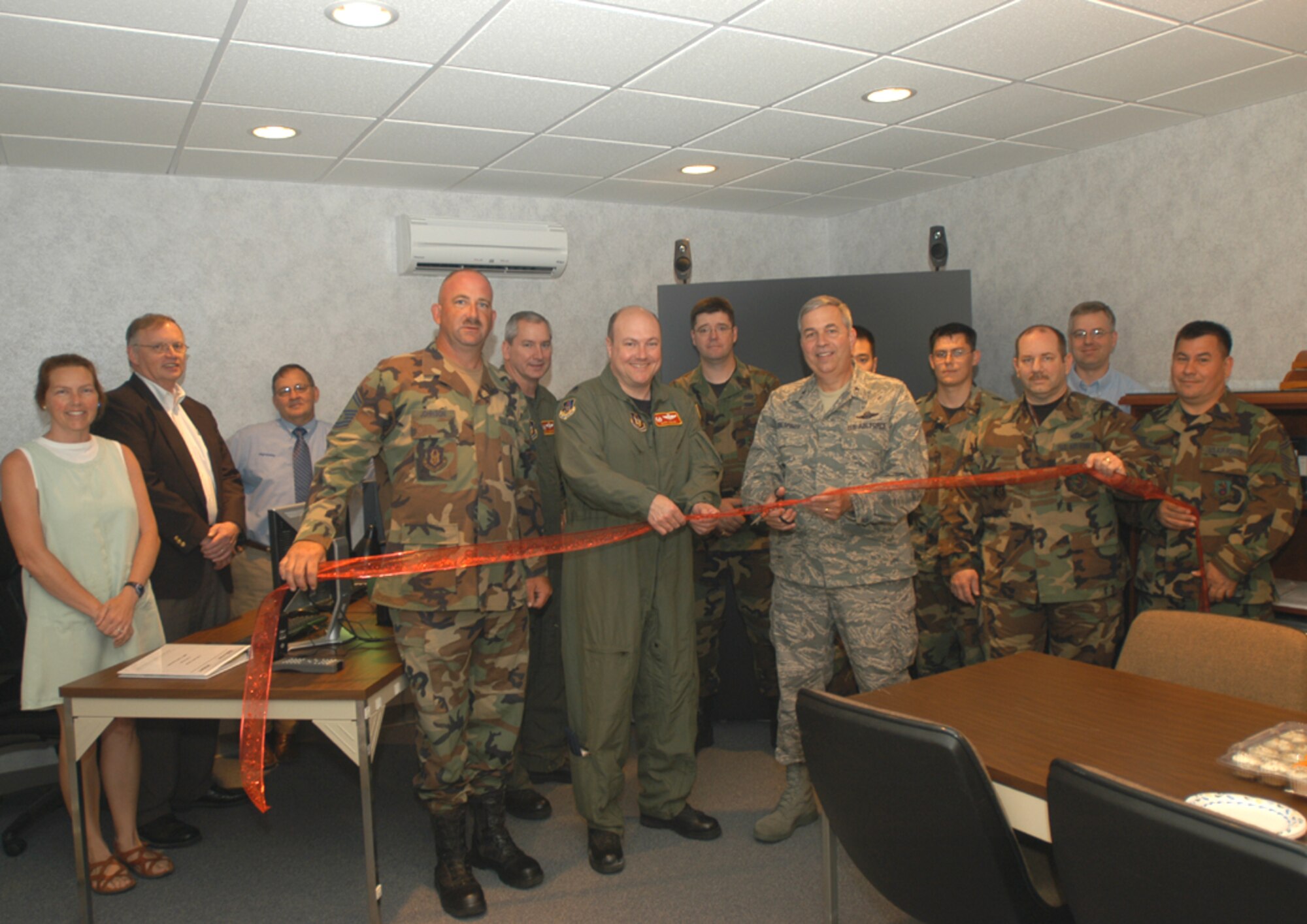 GRISSOM AIR RESERVE BASE, Ind., -- Brig. Gen. Dean Despinoy, 434th Air Refueling Wing commander, center with scissors, cuts the ribbon to officially open the Visual Threat Recognition and Avoidance Training room here June 15. The general is joined by members of the base who were influential in getting the room renovated and the equipment installed. Members of the 434th Civil Engineering Squadron turned an old mechanical room into secure training environment. Grissom is one of four KC-135R Strantotanker wings to receive the VTRAT system, and the only AFRC unit. (U.S. Air Force photo/Tech. Sgt. Doug Hays)