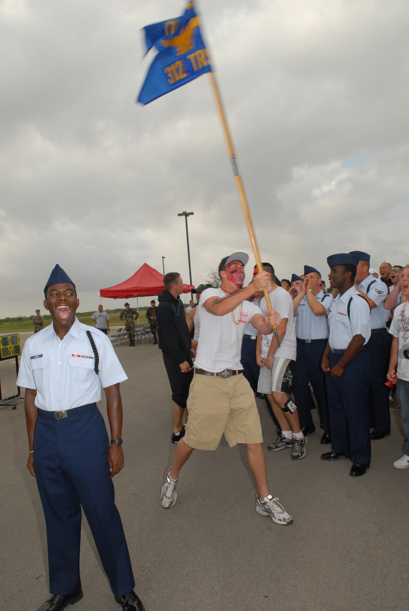 Airman Basic Jermaine Joseph of the 312th Training Squadron drill team calls out a squadron yell as a fellow “firedawg” waves the guidon high at the 17th Training Group drill competition June 9. The 312 TRS was awarded the spirit award, recognizing the squadron with the loudest and most dedicated fans (U.S. Air Force photo by Tech. Sgt. Randy Mallard).
