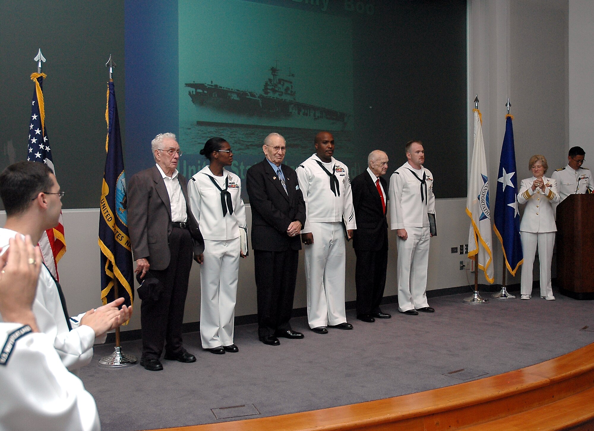 Battle of Midway veterans are applauded during a ceremony in their honor June 6.  They are (in civilian clothes, from left), retired Navy Chief Petty Officer Lester Murray, retired Army Chief Warrent Officer Floyd Campbell and retired Navy Chief Warrant Officer Frank Boo.