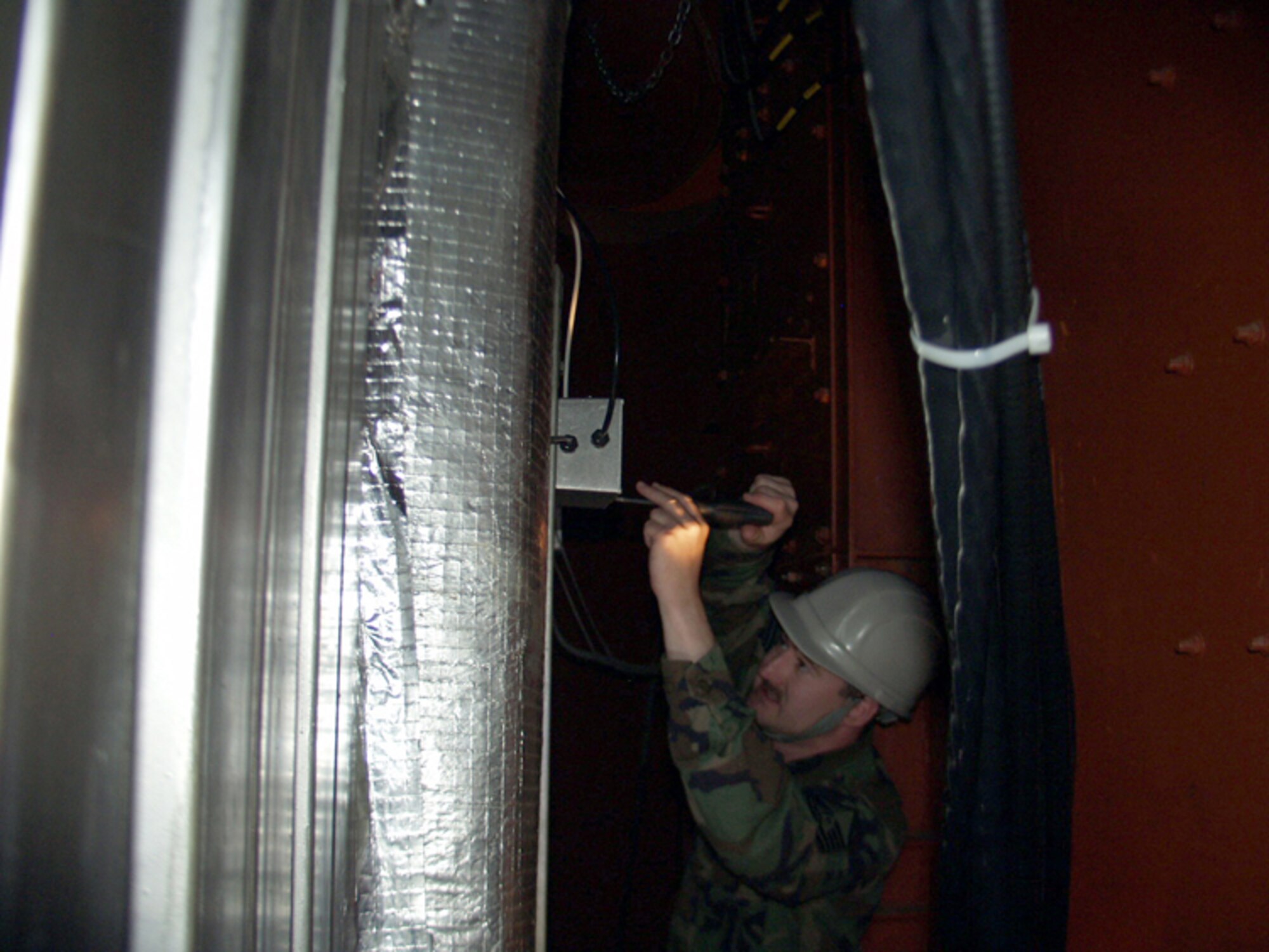Master Sgt. Richard Hamill, 341st Maintenance Operations Squadron, connects a television co-axial cable into a filter on the backside of a launch control capsule as part of the NetLink installation.  The NetLink system allows the operators to access the base network and provides other features to enhance their capabilities while on alert.   (Couresty photo)