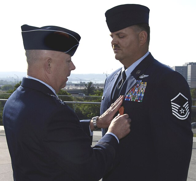 Gen. T. Michael Moseley awards Master Sgt. Byron Allen with the new Air Force Combat Action Medal at a ceremony in Washington, D.C., Tuesday. Sergeant Allen, 1st Special Operations Group, was one of six Airmen from the entire Air Force selected to participate in the historic ceremony. (U.S. Air Force photo by Ilene Allen)