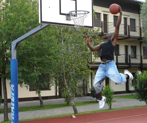 SPANGDAHLEM AIR BASE, GERMANY -- Airman 1st Class Jerry "Handles" Murrell, 52nd Security Forces Squadron, attempts to slam dunk a basketball June 7 at Spandahlem AB. Fitness is everyone's personal responsibility. (US Air Force photo/Airman 1st Class Stephanie Clark)