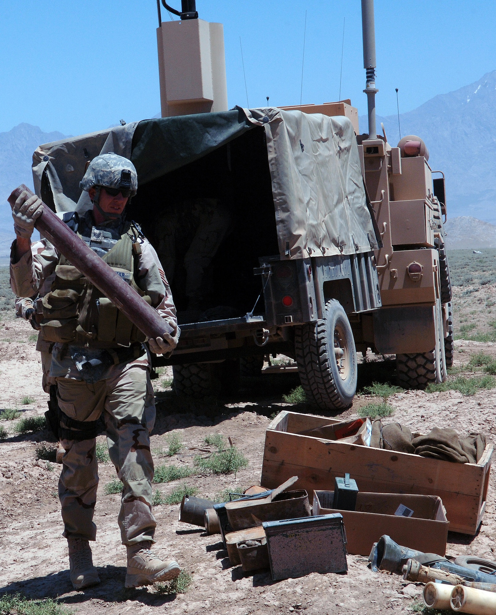 Staff Sgt. Rick Palmar, 755th Expeditionary Explosive Ordnance Disposal assistant team lead, helps unload and arrange more than 1,000 pounds of stored mines, munitions and weapons caches for a controlled detonation outside Bagram Airfield, Afghanistan June 13. (photo by Staff Sgt. Craig Seals)