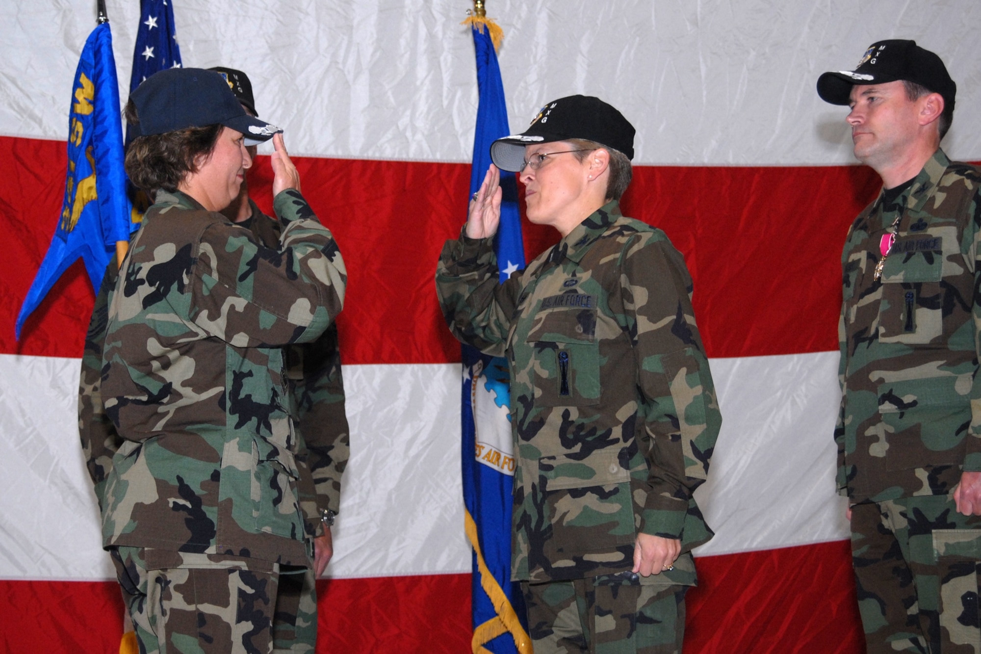 Col. Deborah Kirkhuff, center, salutes 341st Space Wing commander Col. Sandy Finan after accepting command of the 341st Maintenance Group June 8.  Outgoing 341st MXG commander Col. William Hughes, right, looks on.