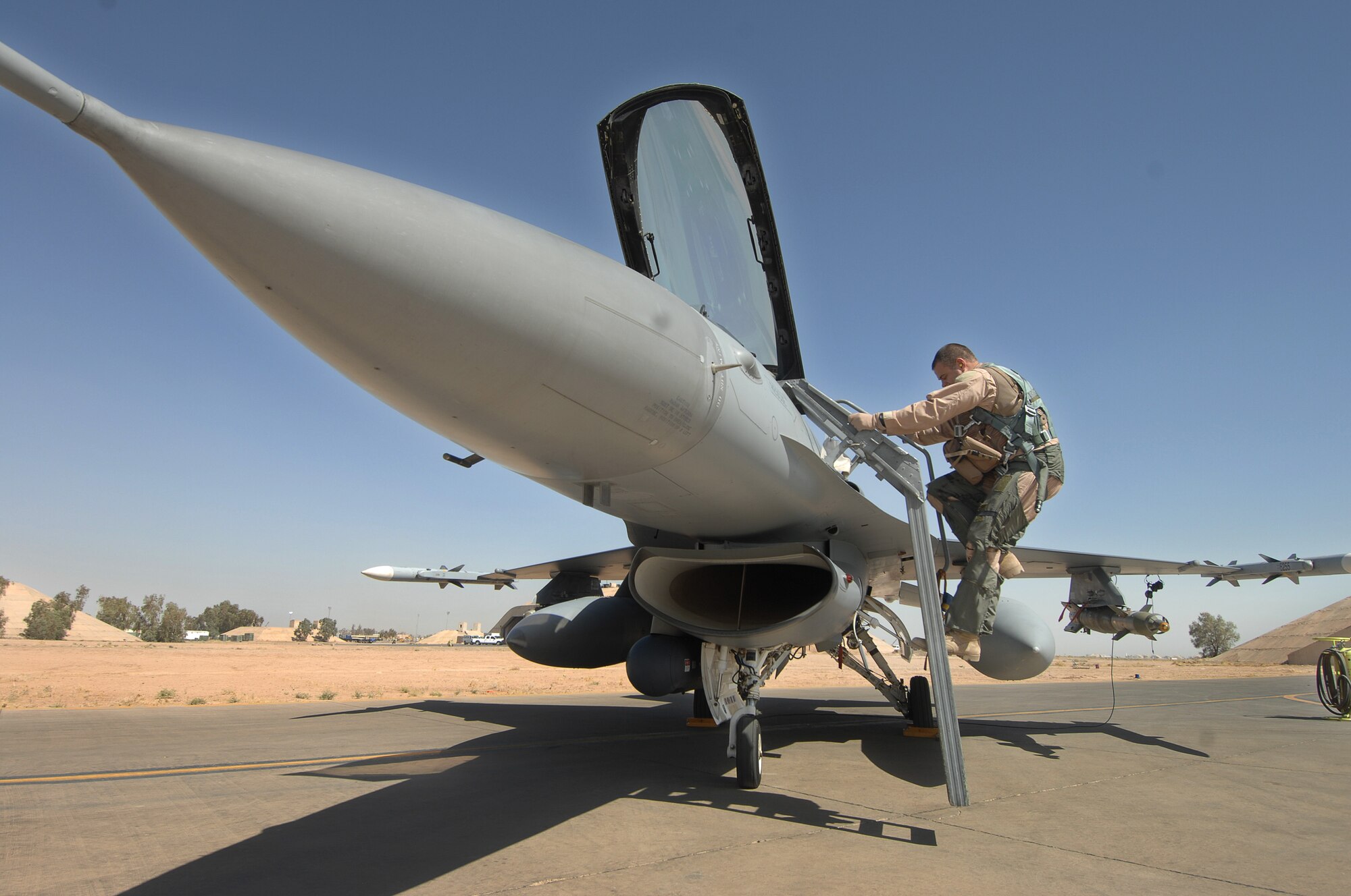 BALAD AIR BASE, Iraq -- Maj. Brian Chamness, 332nd Expeditionary Fighter Squadron, climbs aboard his F-16 before a combat mission June 14. The 332nd EFS is part of the 332nd Air Expeditionary Wing here. The Wing represents a total force unit with Reservists, Air National Guardsmen and Active Duty Air Force Airmen. General Bradley is visiting Airmen throughout Southwest Asia who are supporting the Global War on Terrorism. U.S. Air Force photo by Tech. Sgt. Rick Sforza (RELEASED)