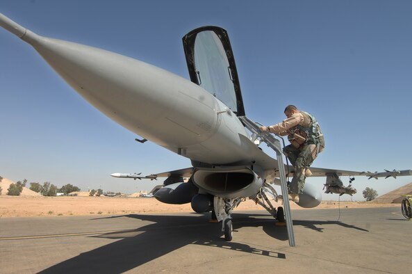 BALAD AIR BASE, Iraq -- Maj. Brian Chamness, 332nd Expeditionary Fighter Squadron, climbs aboard his F-16 before a combat mission June 14. The 332nd EFS is part of the 332nd Air Expeditionary Wing here. The Wing represents a total force unit with Reservists, Air National Guardsmen and Active Duty Air Force Airmen. General Bradley is visiting Airmen throughout Southwest Asia who are supporting the Global War on Terrorism. U.S. Air Force photo by Tech. Sgt. Rick Sforza (RELEASED)