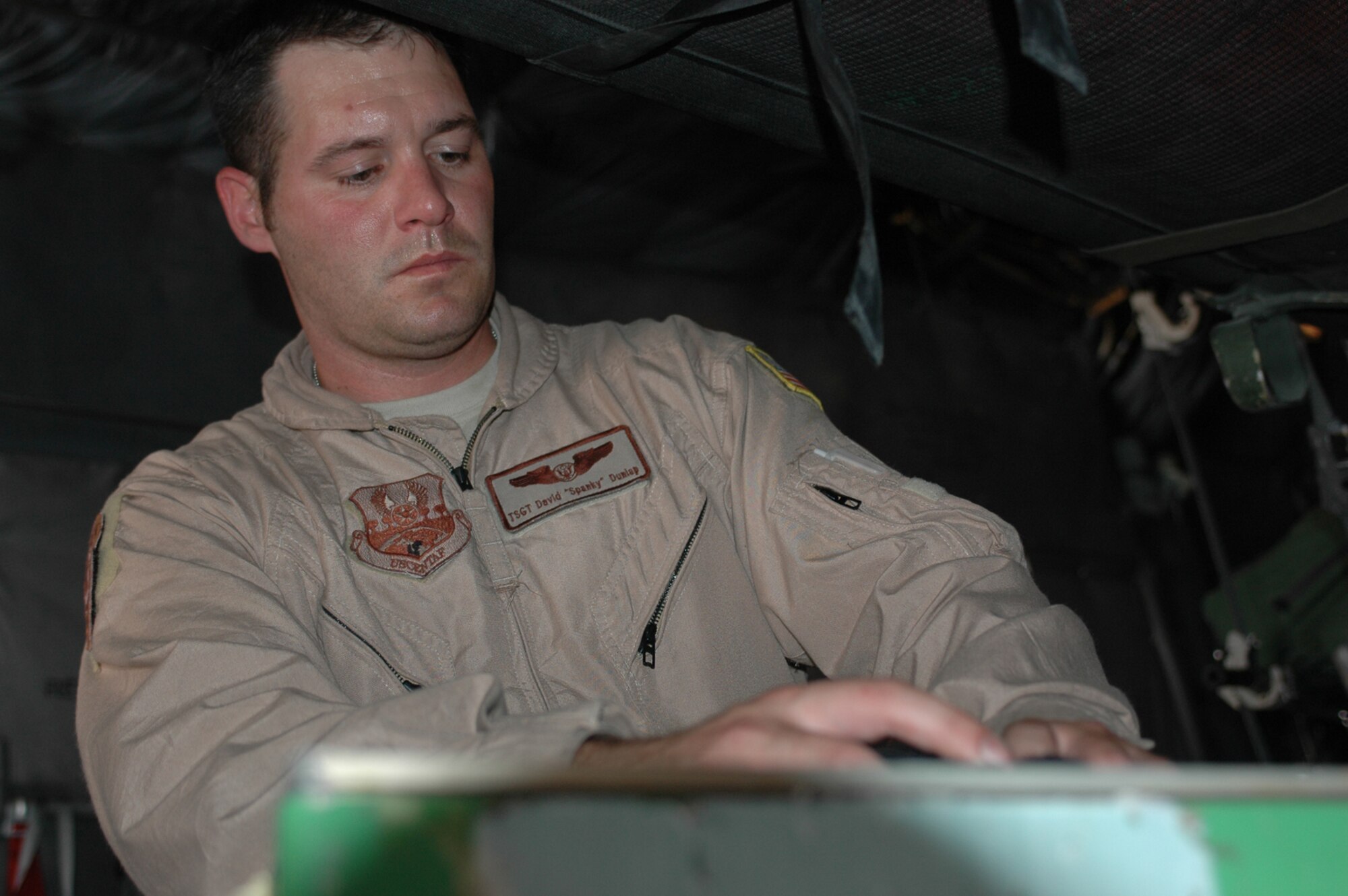 Tech. Sgt. David Dunlap, 379th Expeditionary Aeromedical Evacuation Squadron, prepares his equipment prior to take off. (U.S. Air Force photo by Staff Sgt. Cassandra Locke)