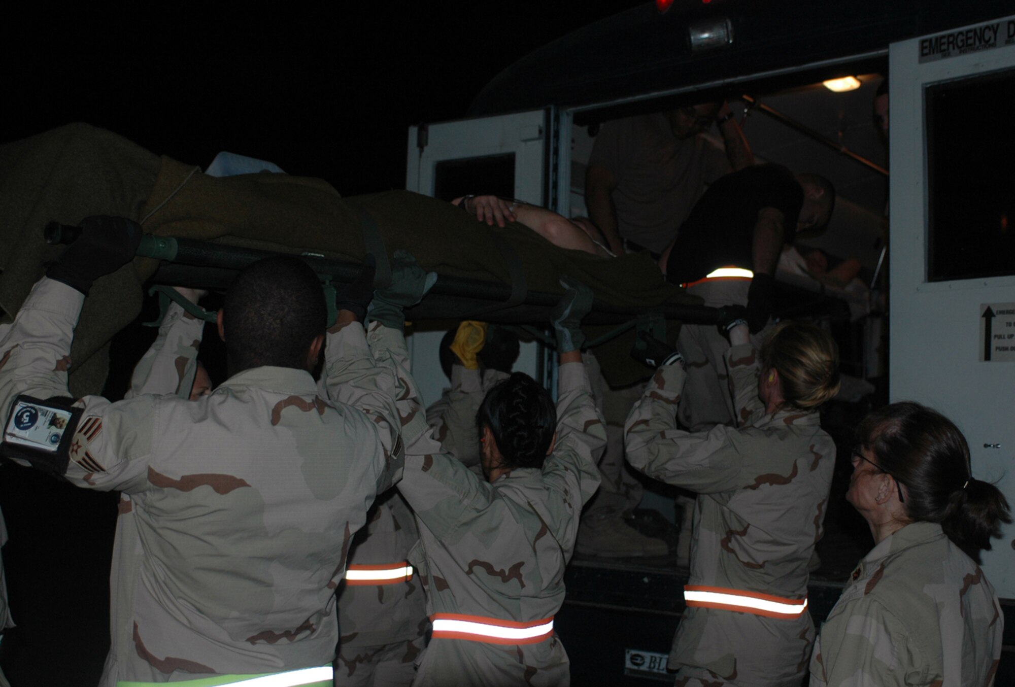 A medical team loads a patient onto an ambulance on the flightline to recieve care at the base hospital. Patients were transfered from Al Asad Air Base, Iraq, here to receive further care.  (U.S. Air Force photo by Staff Sgt. Cassandra Locke)