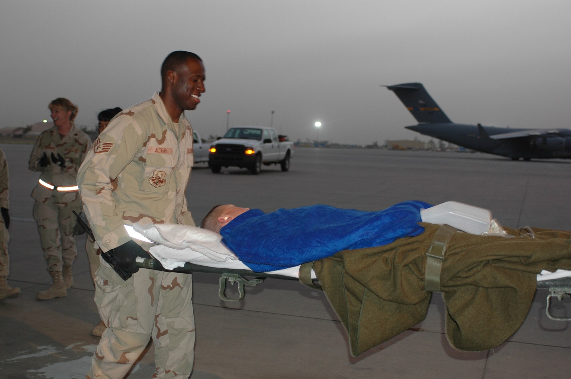Staff Sgt. Wilsondo Alteus, 332nd Expeditionary Aerospace Medical Division Squadron, helps transport a patient onto a C-130 aircraft heading for a base in Southwest Asia.  (U.S. Air Force photo by Staff Sgt. Cassandra Locke)