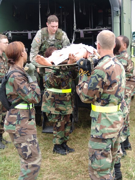 U.S. Army Specialist Aaron Tripp, 477th medical Company ground ambulance, Minnesota Army National Guard (top), assists members of the 706th Provisional contingency aeromedical support facility, in unloading patients from the Army's combat support hospital at Fort Gordon, Ga., during Golden Medic 2007. 
