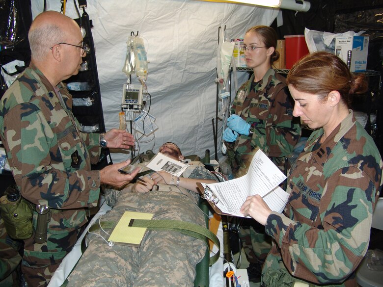 Lt. Col. Bill Bailey (left), cardiologist and flight surgeon with the 433rd Medical Group, Lackland Air Force Base, Texas, instructs Senior Airman Valerie Haines, a medical technician with the 177th Medical Group, New Jersey Air National Guard at Golden Medic 2007, while Capt. Soledad Lopez, a nurse with the 156th Medical Group, Puerto Rico Air National Guard reviews a patient chart. They are with the 706th Provisional Expeditionary Medical Support Squadron while assigned to Golden Medic 2007 at Fort Gordon, Ga. 