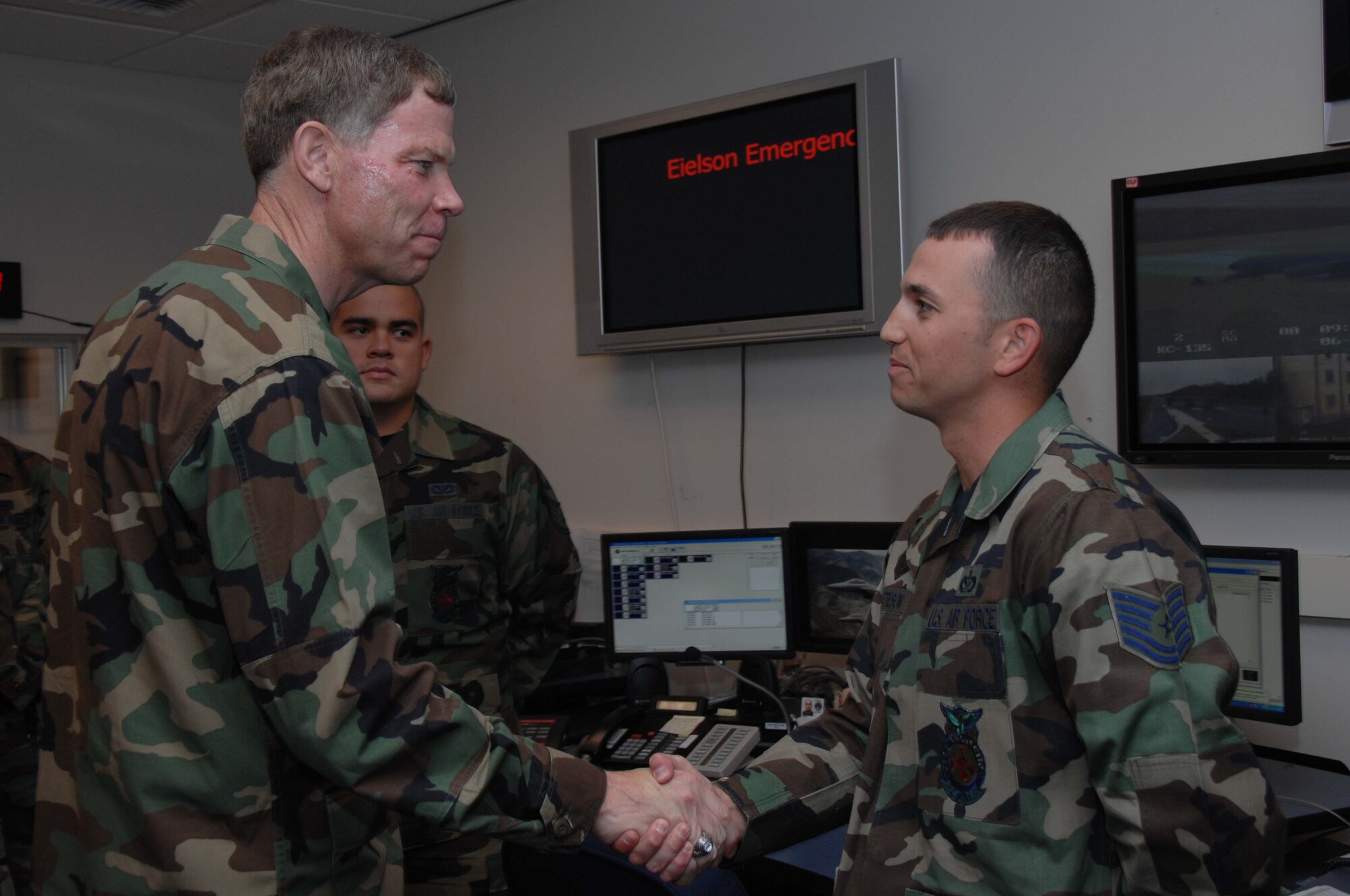 EIELSON AIR FORCE BASE, Alaska -- Maj. Gen. Del Eulberg, Air Force Civil Engineer Headquarters U.S. Air Force, tours the 354th Security Forces Squadron law enforcement desk and presents a coin to Tech. Sgt. Richard Matteson, 354th Civil Engineering Squadron fire fighter, during his visit to Eielson June 18.  (U.S. Air Force photo by Staff Sgt. Tia Schroeder) 