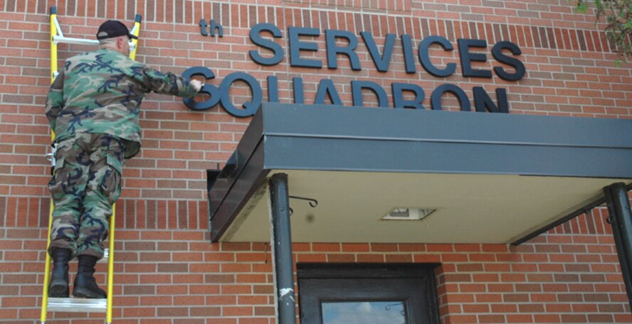MINOT AIR FORCE BASE, N.D. -- Staff Sgt. Franklin Sides, 5th Civil Engineer Squadron, removes the 5th Services Squadron sign above a doorway at the 5th Bomb Wing headquarters building here June 8. The former 5th Services Squadron and the former 5th Mission Support Squadron merged to form the new 5th Force Support Squadron during a redesignation ceremony here June 11. (U.S. Air Force photo by Airman 1st Class Wesley Wright)