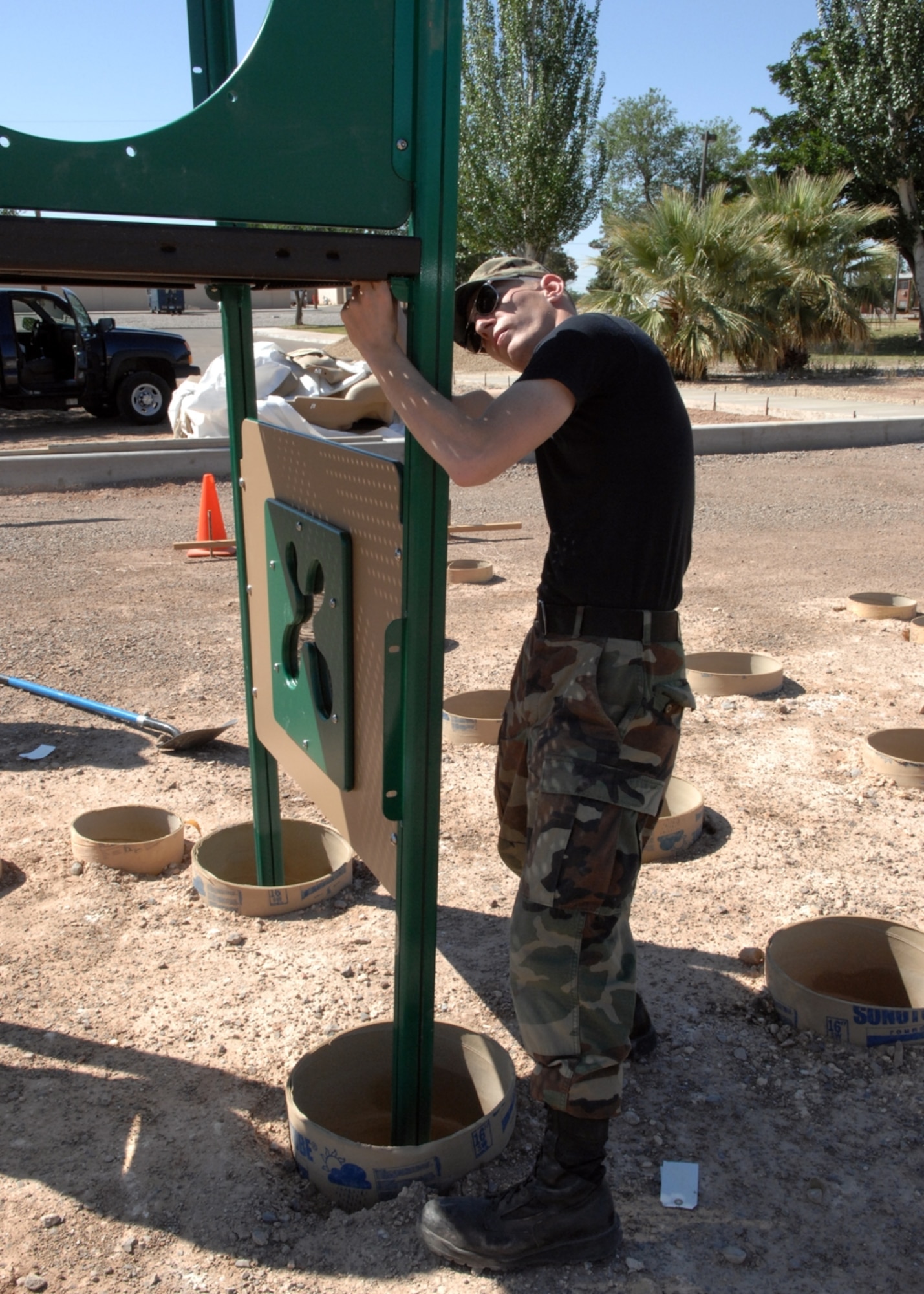 An Airman from the 49th Civil Engineer Squadron puts together a piece of the new playground to be completed at Steinhoff Park next to bowling alley. (U.S. Air Force photo/Airman 1st Class Rachel Kocin)