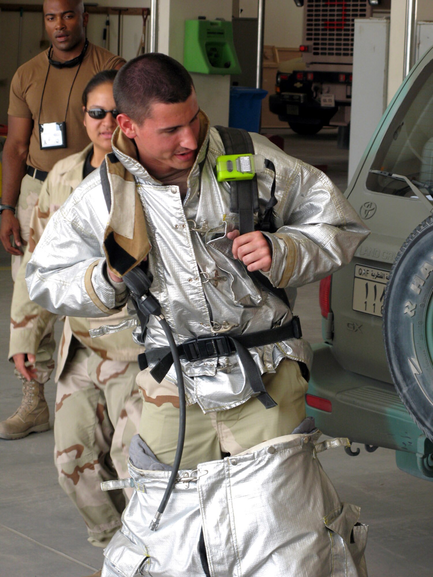 Air Force Academy cadet Ian Turner puts on a fire suit during a tour of a fire department while deployed in Southwest Asia. Sixteen cadets participating in Operation Air Force are getting their first taste of what it is like to deploy in support of operations Iraqi and Enduring Freedom and operations in the Horn of Africa. (Courtesy photo)