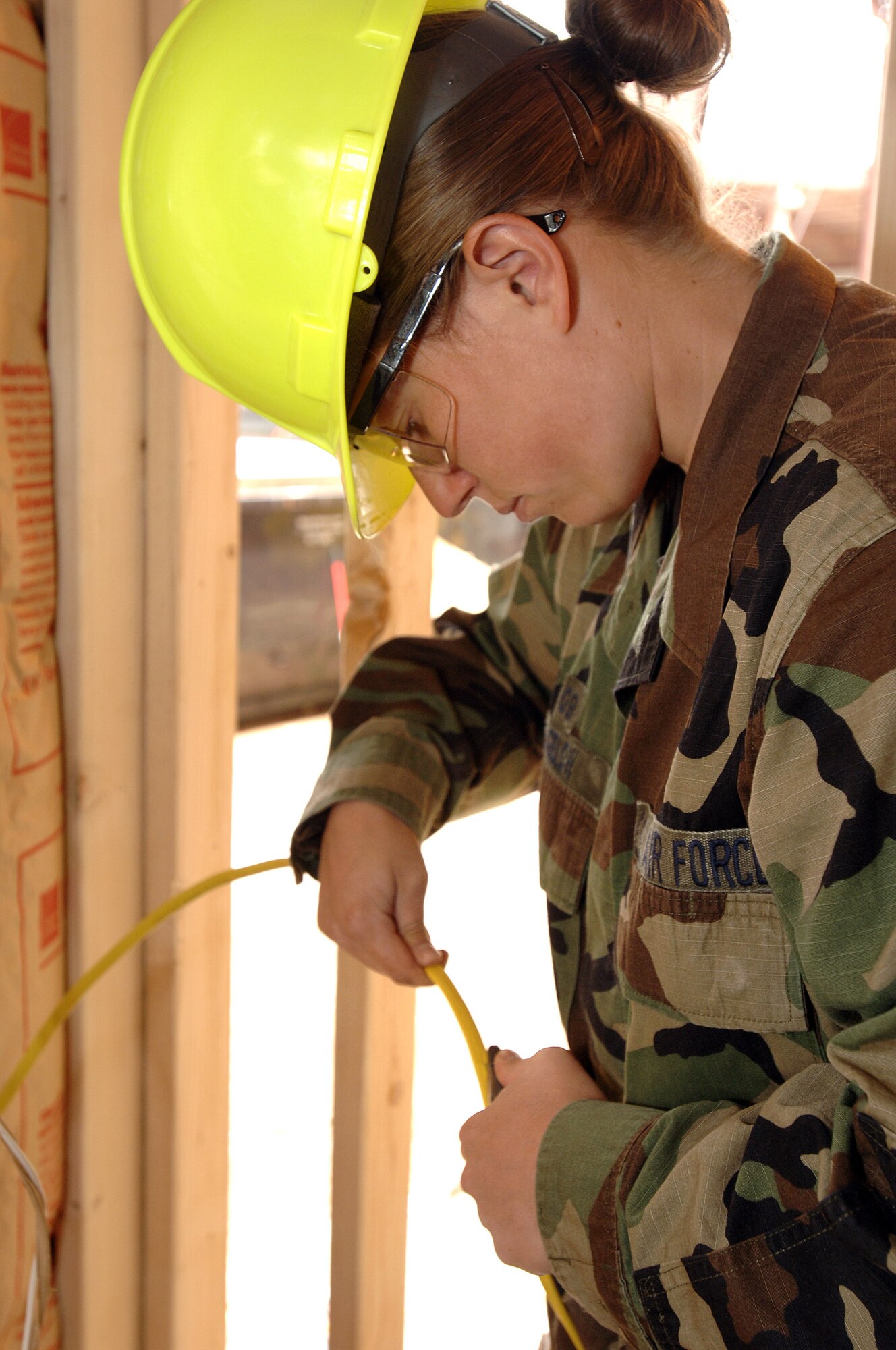 Air Force Academy Cadet 2nd Class Holly Bigalow installs wiring in a house being built by cadets during the Field Engineering and Readiness Laboratory course at the Academy.  The course exposes cadets to several aspects of civil engineering, including heavy equipment operation, steel bridge construction, designing and pouring concrete beams and paving portions of a road. (U.S. Air Force photo/Mike Kaplan)