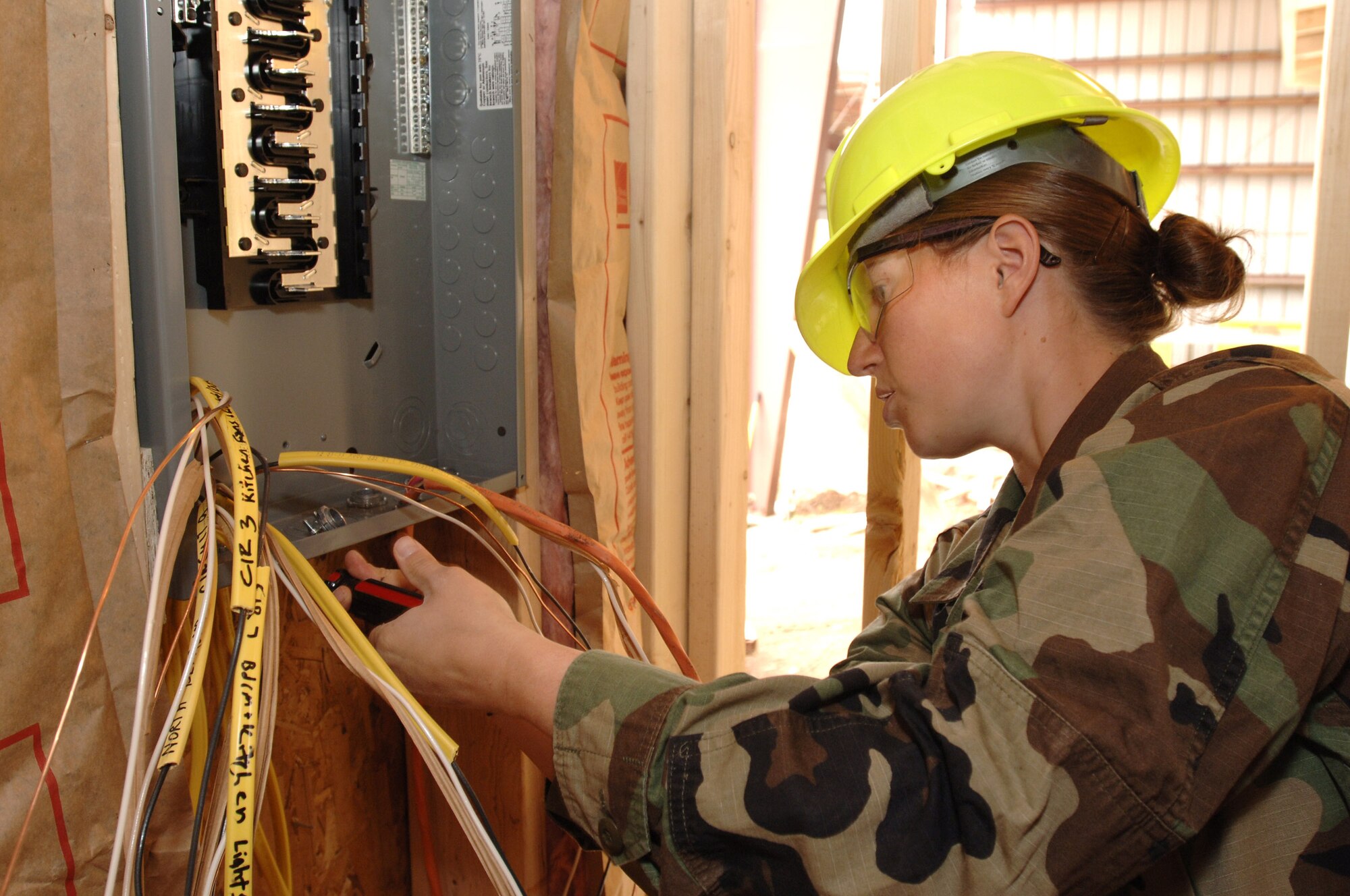 Air Force Academy Cadet 2nd Class Holly Bigalow installs wiring in a house being built by cadets during the Field Engineering and Readiness Laboratory course at the Academy.  The course exposes cadets to several aspects of civil engineering, including heavy equipment operation, steel bridge construction, designing and pouring concrete beams and paving portions of a road. (U.S. Air Force photo/Mike Kaplan)