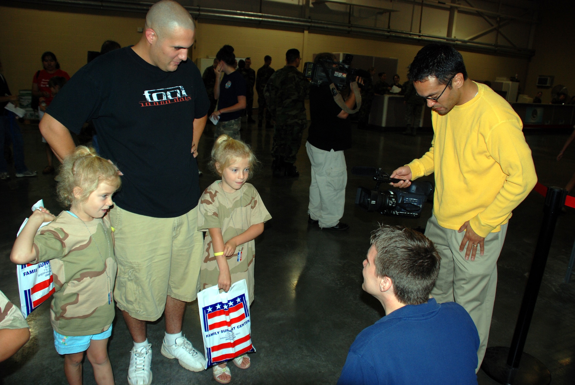 Keaton Fox, a reporter with KFDX channel 3, interviews Trinity and Destiny Chisum, daughters of Airman 1st Class Billy Chisum, June 16 at Operation Kids Investigating Deployment Services. (U.S. Air Force photo/Airman 1st Class Jacob Corbin)