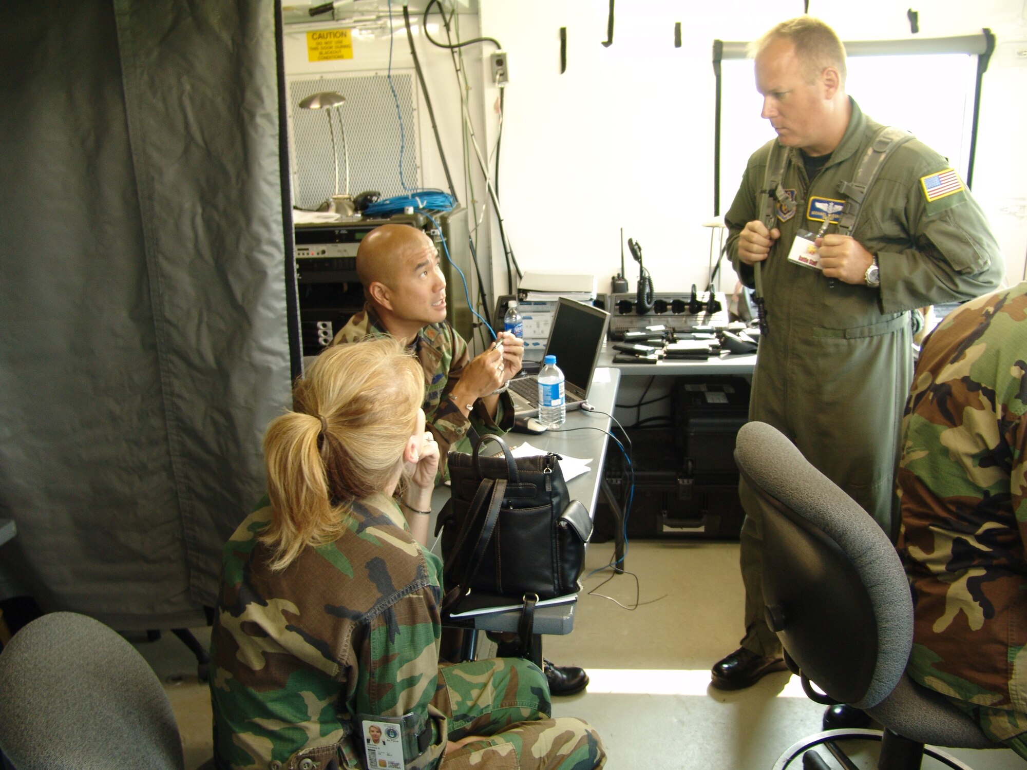 Maj. Zebedee Lau (center), 94th Airlift Control Flight commander, Dobbins Air Reserve Base, Ga., discusses communication issues with Senior Master Sgt. Michael McDonald, 22nd Air Force expeditionary mobility operations superintendent, Dobbins Air Reserve Base, Ga., and Maj. Cynthia Ritchey, 22nd Air Force chief of expeditionary mobility operations, during Golden Medic 2007 at the Augusta Regional Airport - Bush Field, Ga.