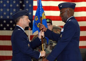 Col. Mark Barrett, 1st Fighter Wing commander, hands the guidon to Col. Tyrone Strachan, the incoming 1st Maintenance Group commander, while Chief Master Sgt. Dennis Krebs, 1st MXG superintendent, stands ready to receive the guidon during the 1st MXG change of command ceremony here June 15. Previously, Colonel Strachan served as the deputy commander the of the 18th Maintenance Group at Kadena Air Base, Japan and before that, he commanded Langley's 1st Aircraft Maintenance Squadron. (U.S. Air Force photo/Senior Airman Tabitha Kuykendall)
