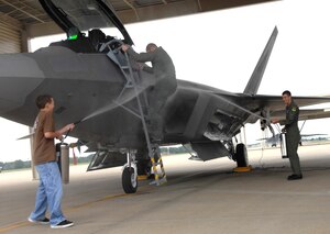 Lt. Col. Dirk Smith, 1st Operations Group deputy commander, receives a cool welcome from his son, Garrett, and 2nd Lt. Matthew Kless, 94th Fighter Squadron student pilot, after his fini flight June 15. Colonel Smith, who previously commanded the 94th FS, will continue his education at Air War College, Maxwell Air Force Base, Ala. (U.S. Air Force photo/Senior Airman Tabitha Kuykendall)