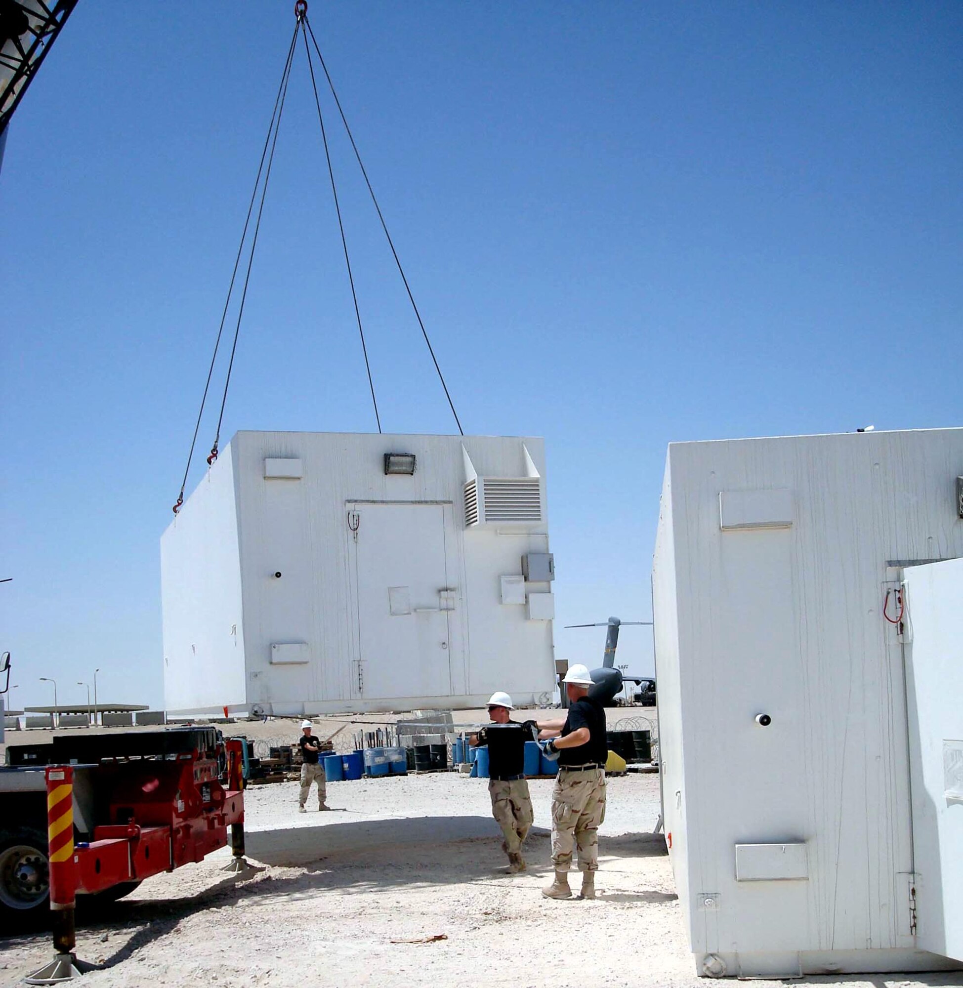 Members of the 379th Air Expeditionary Wing help place and set up two portable armories June 8 in Southwest Asia. The new armories will allow the 379th Expeditionary Logistics Readiness Squadron to roll up operations at one of the two current armory locations, and combine their operations at a single armory location. (U.S. Air Force photo/1st Lt. Steven Moore)          