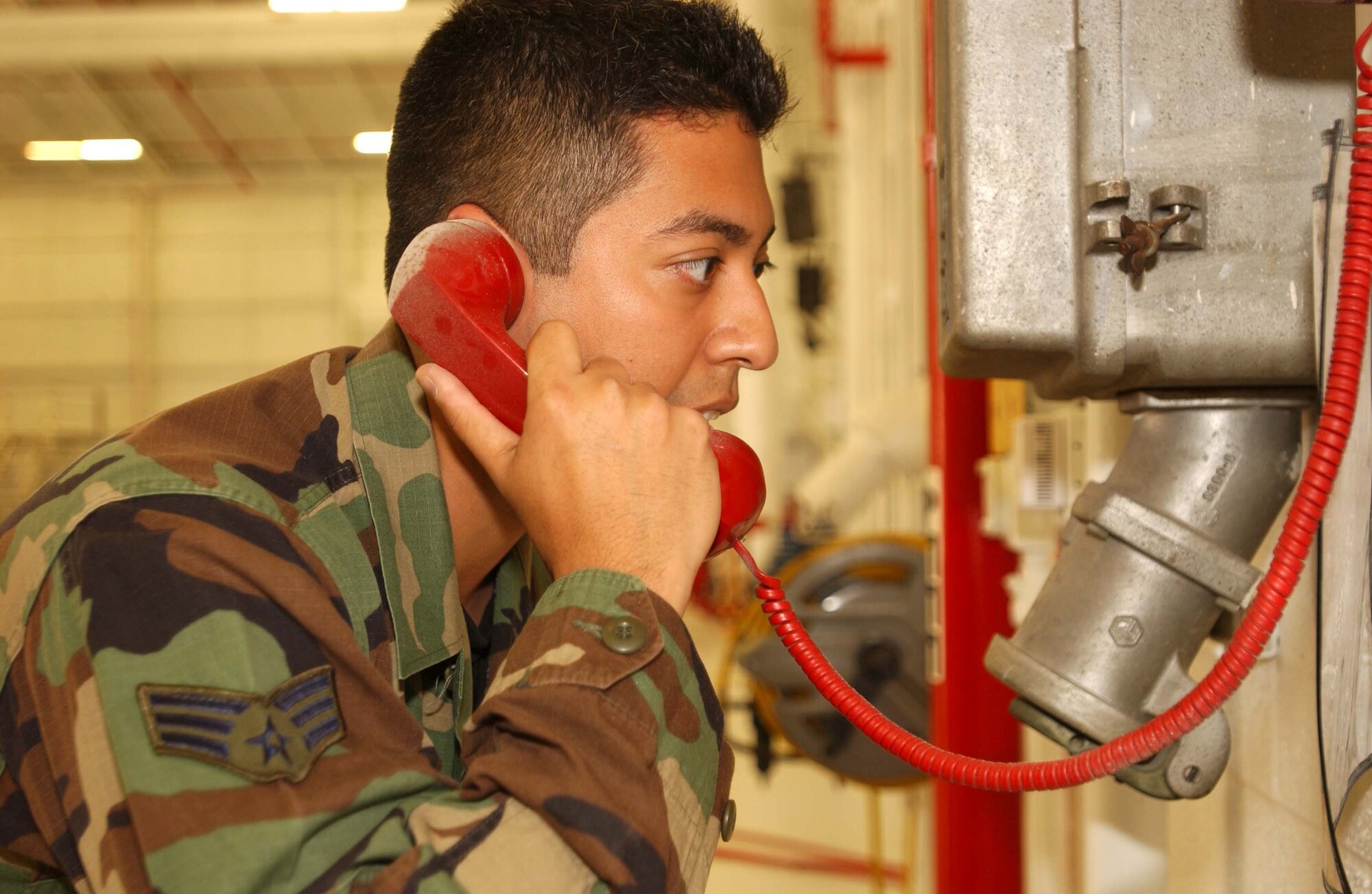 ANDREWS AIR FORCE BASE, Md. -- Senior Airman James Gomez calls for help on the emergency phone to first responders during a fuel cell extraction exercise June 4. Airman Gomez is a 459th Maintenance Squadron aircraft fuels system technician. (U.S. Air Force photo/Staff Sgt. Amaani Lyle)