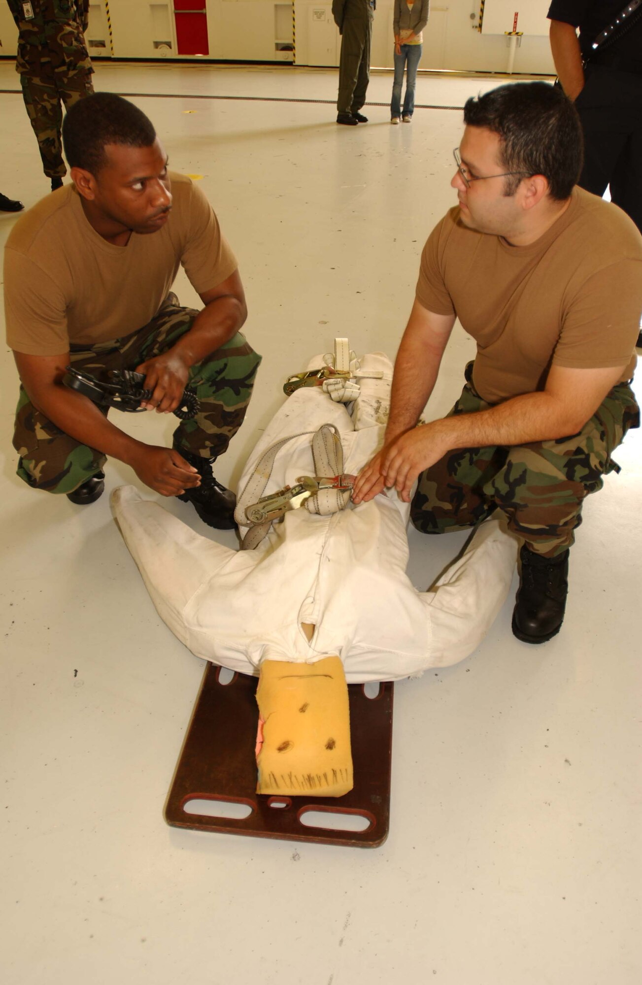 ANDREWS AIR FORCE BASE, Md. -- Staff Sgt. Deangelo Williams, 316th Civil Engineer Squadron fire protection flight crew chief, and Staff Sgt. Daniel Garced, 459th Maintenance Squadron aircraft fuels systems technician, communicate with each other while checking vitals on a training aid dummy during a fuel cell extraction exercise June 4. (U.S. Air Force photo/Staff Sgt. Amaani Lyle)