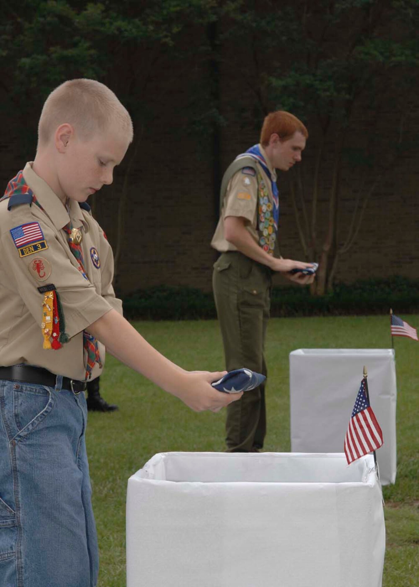 SHAW AIR FORCE BASE, S.C. -- Nathan, son of Val and Senior Master Sgt. Brian Davis (left), 20th Civil Engineer Squadron, unaccompanied housing section chief and Michael, son of Anna and Glenn Maggard, 9th AF personnel civilian, place unserviceable flags into a box while taking part in a flag retirement ceremony June 14. The ceremony was part of the Flag Day commemoration events. In accordance with the U.S. Flag Code 36S 176, “the flag, when it is in such condition that it is no longer a fitting emblem of display, should be destroyed in a dignified way". (U.S. Air Force photo/ Airman 1st Class William Coleman)
