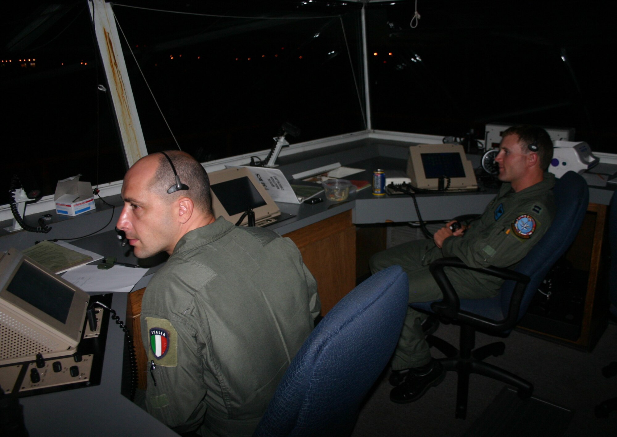 Italian Air Force Capt. Salvatore Lombardi and Capt. Adam Roberts man the runway supervisory unit June 14. The RSU monitors take offs and landings during night flying training. (U.S. Air Force photo/Airman 1st Class Jacob Corbin)