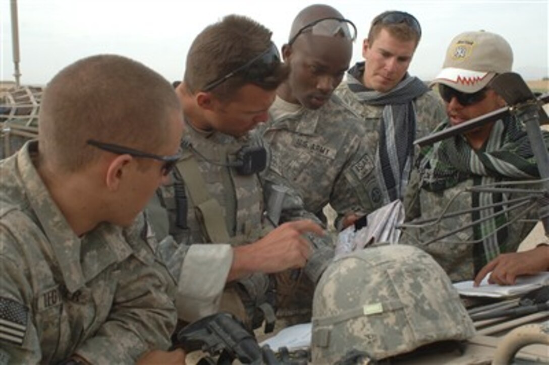 U.S. Army soldiers from Delta Company, 2nd Battalion, 508th Parachute Infantry Regiment discuss intelligence gathered after a meeting with special agents from the Afghan National Police in the Ghazni Province of Afghanistan on June 7, 2007.  