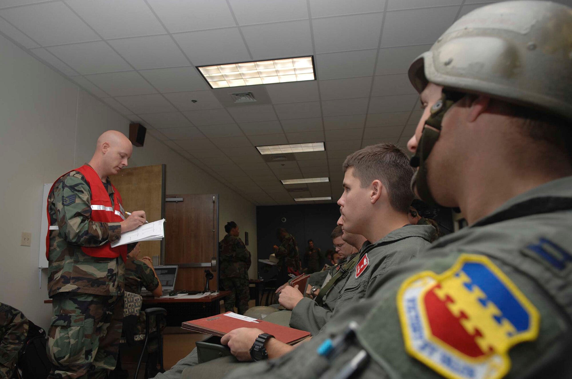 SHAW AIR FORCE BASE, S.C. -- Staff Sgt. Brian Ailstock, 20th Medical Support Squadron pharmacy technician, briefs about prohibited items and other concerns involving the exercise deployed location to Captains Lee Bryant (middle) and Todd Adams (right) and other F-16 Fighting Falcon pilots from the 77th Fighter Squadron during a phase I operational readiness exercise at the Chandler Deployment Processing Center June 18. Phase I exercises are important because they allow the wing to assess large deployment capability in a controlled environment against a set standard. (U.S. Air Force photo/ Staff Sgt. Nathan Bevier)