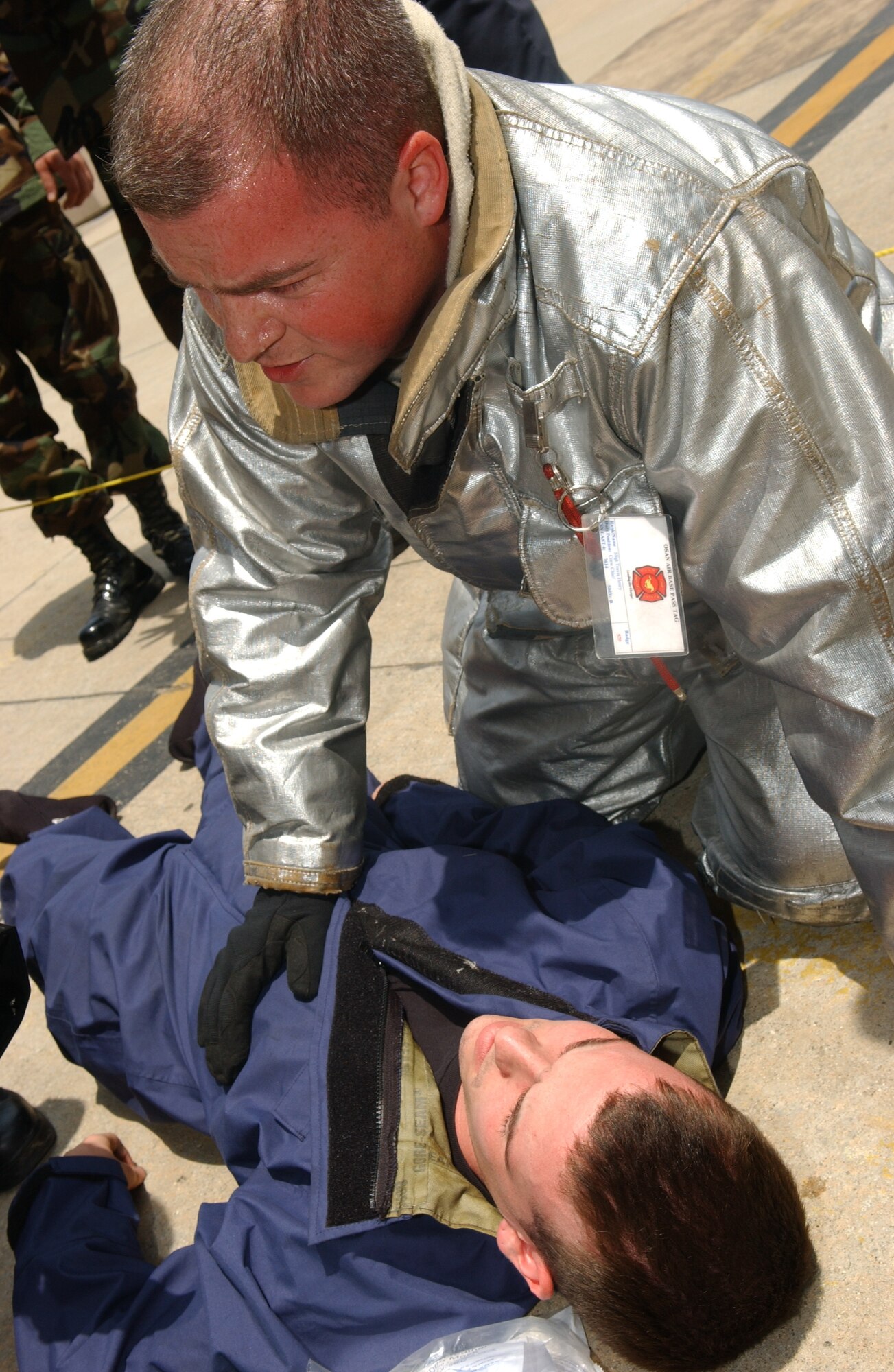 OSAN AIR BASE, Republic of Korea - Senior Airmen Michael Teauge, 51st Maintenance Squadron fuel system repair technician is attended to by emergency personnel after being pulled from a confined space trainer on June 15 during an emergency extraction exercise.  The trainer was used in an extraction exercise that tested the ability of the maintainers as well as 51st Civil Engineer fire department in the ability to remove individuals from confined spaces.  (U.S. Air Force photo by Staff Sgt. Christopher A. Marasky)confined spaces.  (U.S. Air Force photo by Staff Sgt. Christopher A. Marasky)